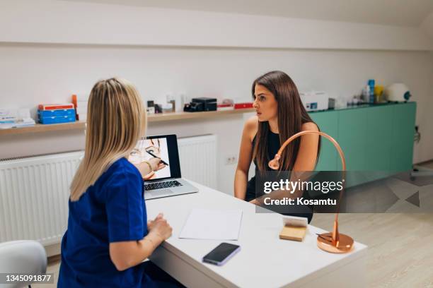 the focused patient listens to the dermatologist's advice about hyaluronic acid and fillers - dermatologists talking to each other patient stock pictures, royalty-free photos & images