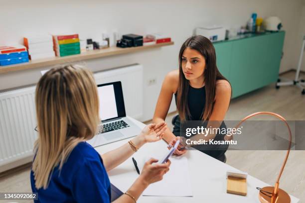 female doctor in ordination talking with young woman patient about plastic surgery - dermatologists talking to each other patient stock pictures, royalty-free photos & images