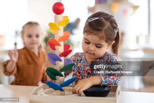 two pre-school girls playing with marble run indoors in nursery, montessori education. - dagis bildbanksfoton och bilder