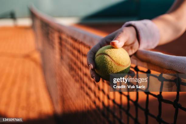 mano che tiene una palla da tennis - tennis foto e immagini stock