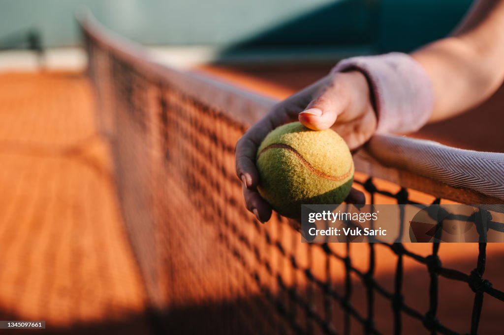 Hand holding a tennis ball