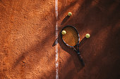 Tennis racket and tennis balls on clay court