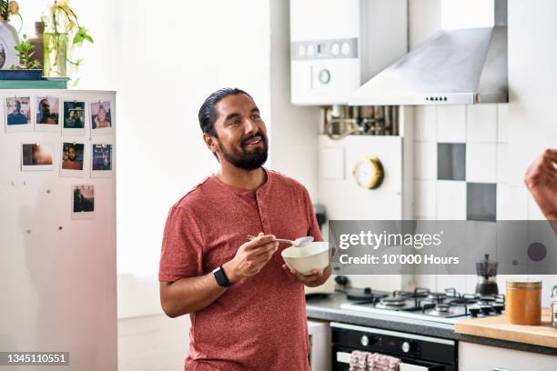 mid adult indian man eating breakfast in flat - healthy eating stock pictures, royalty-free photos & images