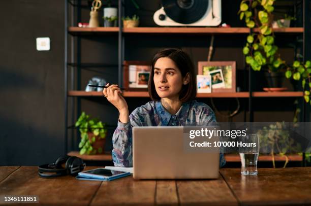 mid adult businesswoman using laptop and looking away - think fotografías e imágenes de stock