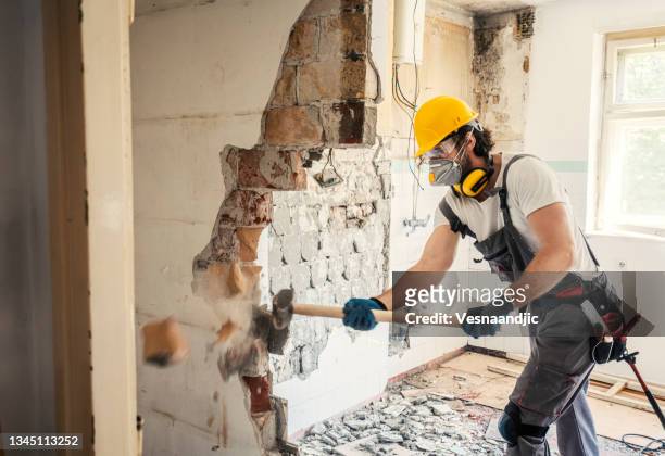arbeiter mit hammer - construction workers stock-fotos und bilder