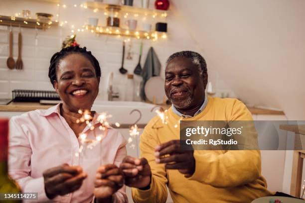 senior african american couple celebrating new year 2022 - old man woman christmas stockfoto's en -beelden