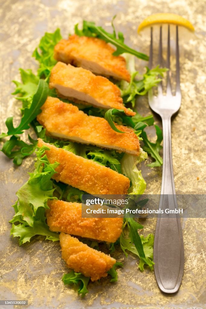 A gluten-free chicken escalope on a bed of lettuce