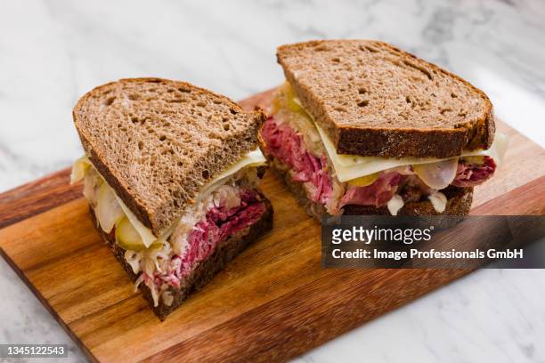 a reuben sandwich with pastrami, sauerkraut and cheese (usa) - reiben stock pictures, royalty-free photos & images