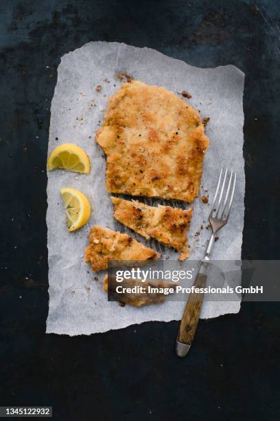 classic viennese veal escalope on grease-proof paper, sliced - wiener schnitzel stock pictures, royalty-free photos & images