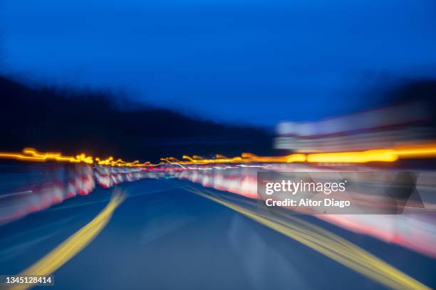 moving image of a car driving at night on a road under construction. - dui stock-fotos und bilder