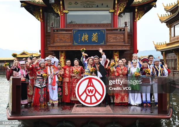 Newly-wed couples attend a group wedding ceremony at the West Lake during Chinese National Day holiday on October 6, 2021 in Hangzhou, Zhejiang...