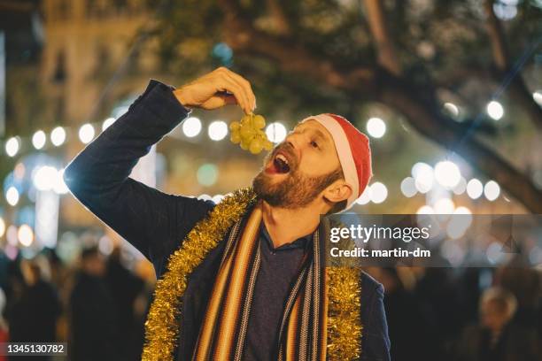 man eating grape at new year's eve in spain - number 12 stock pictures, royalty-free photos & images