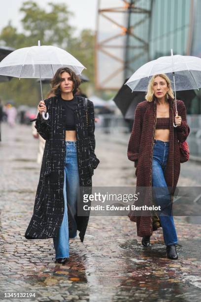 Guest wears a black cropped t-shirt, a black with white checkered pattern long coat, blue faded denim high waist flared ripped pants, a black shiny...