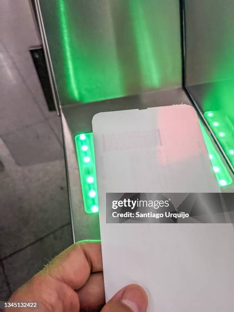 passenger placing his ticket on an automated boarding pass check gate - security pass stockfoto's en -beelden