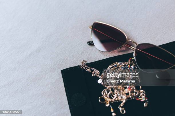 close-up of jewelry and sunglasses on black background. - gold chain necklace stock-fotos und bilder
