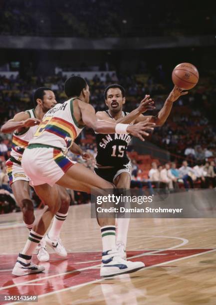 John Lucas, Point Guard for the San Antonio Spurs passes the basketball around Alex English and Mike Evans of the Denver Nuggets during their NBA...
