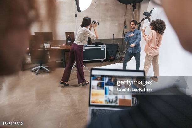 fotografin und ihr team arbeiten in einem modestudio - fotosession stock-fotos und bilder