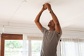 African American Man is changing a light bulb