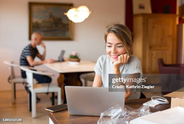 happy woman setting up new laptop computer - new user stock-fotos und bilder