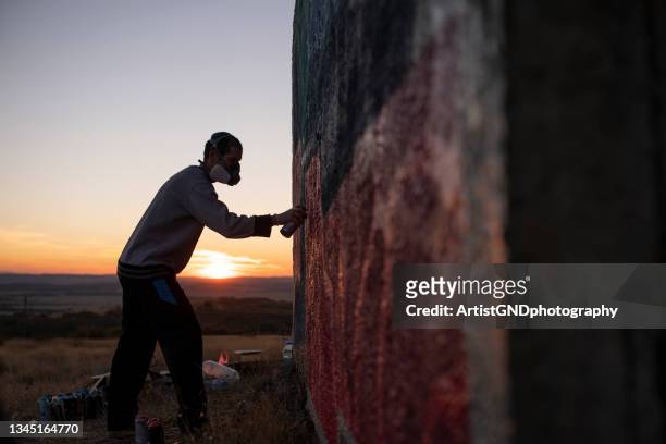 silhouette des straßenkünstlers bei sonnenuntergang. - graffiti artists stock-fotos und bilder