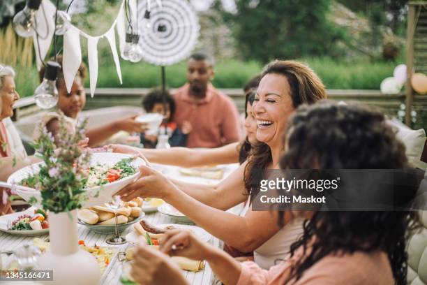 cheerful family in dinner party at backyard - dinner foto e immagini stock