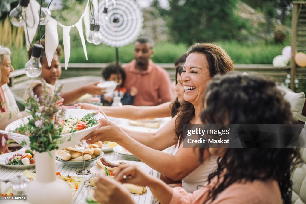 Cheerful family in dinner party at backyard