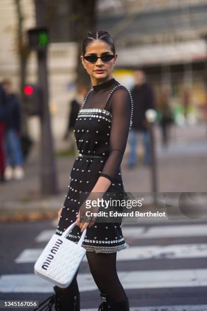 Thassia Naves wears sunglasses, a black transparent long sleeves t-shirt, a black square neck / tank-top / with embroidered crystal borders and...