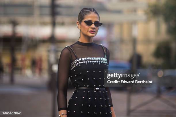 Thassia Naves wears sunglasses, a black transparent long sleeves t-shirt, a black square neck / tank-top / with embroidered crystal borders and...