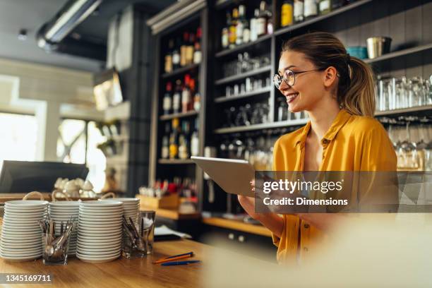 waitress checking out the newest coffee trends online - waiter using digital tablet stock pictures, royalty-free photos & images