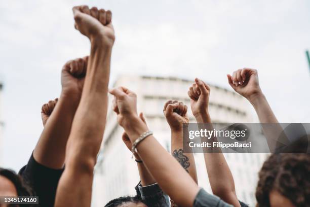 people with raised fists at a demonstration in the city - strike protest action stock pictures, royalty-free photos & images