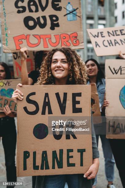 a group of young adult people are marching together on strike against climate change - strike protest action stockfoto's en -beelden
