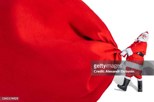 santa claus with a big red bag of gifts on a white background isolated. christmas and new year concept - big bag stock pictures, royalty-free photos & images