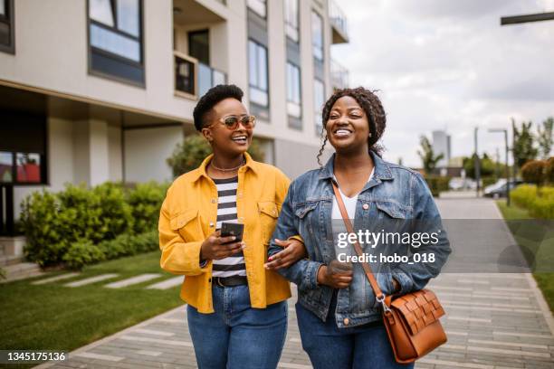 zwei touristenmädchen bei einem stadtspaziergang an sonnigen sommertagen - couple walking shopping stock-fotos und bilder