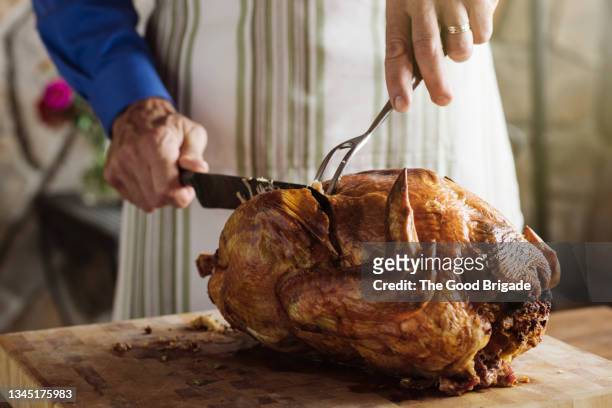 man carving fresh roasted turkey at home - turkey imagens e fotografias de stock