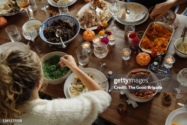 teenage girl having food while sitting at dining table during thanksgiving - side dish stock pictures, royalty-free photos & images
