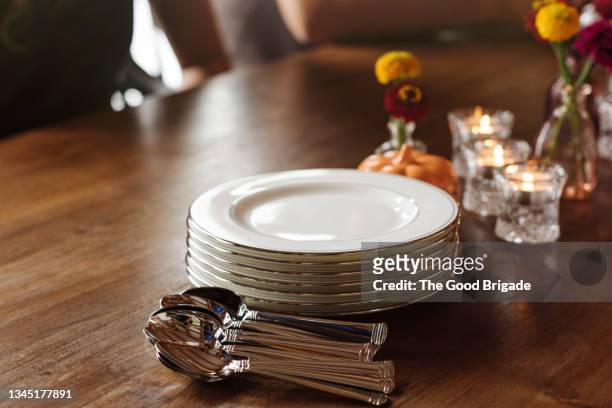plates and spoons on table - dining room set stock pictures, royalty-free photos & images
