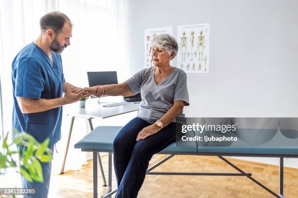 physische arztberatung bei patientenarmproblemen - handgelenk stock-fotos und bilder