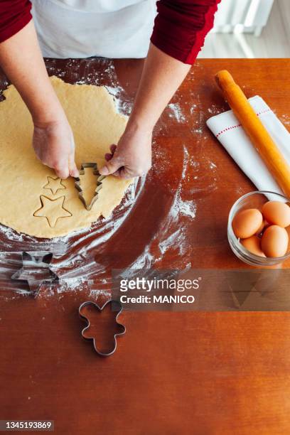 woman cutting christmas cookies - flour christmas stock pictures, royalty-free photos & images