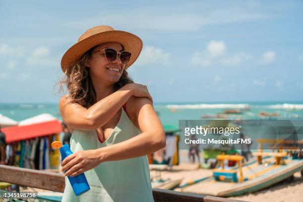 protector solar en la playa - sombrero mujer fotografías e imágenes de stock