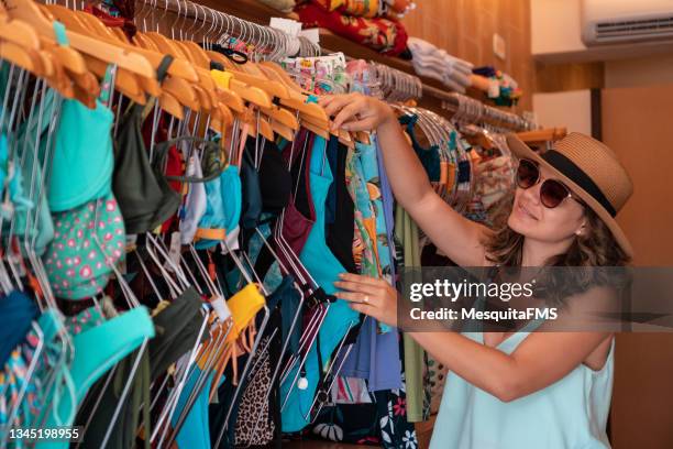 woman choosing bikini at the store - swimwear store stock pictures, royalty-free photos & images