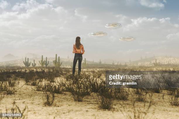woman in desert with flying ufos - conspiracy theories stock pictures, royalty-free photos & images