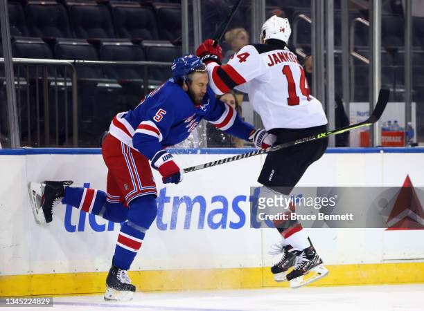 Jarred Tinordi of the New York Rangers checks Mark Jankowski of the New Jersey Devils during the first period during a preseason game at Madison...