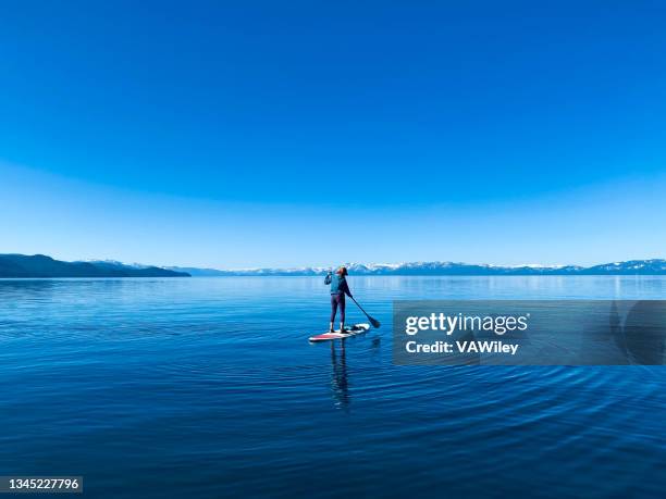 paddle boarding en una tranquila madrugada en lake tahoe, nevada - lake tahoe fotografías e imágenes de stock