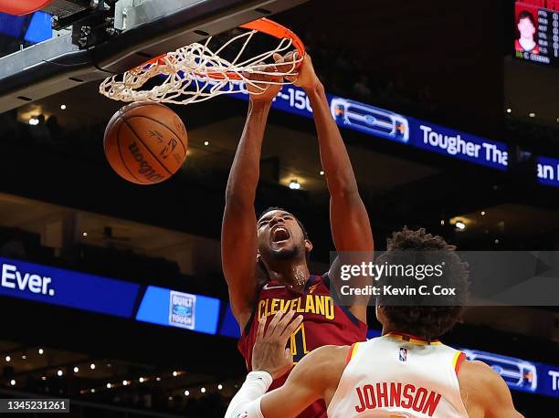 Evan Mobley of the Cleveland Cavaliers dunks against Jalen Johnson of the Atlanta Hawks during the first half at State Farm Arena on October 06, 2021...