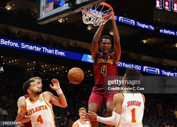 Evan Mobley of the Cleveland Cavaliers dunks against Jalen Johnson and Skylar Mays of the Atlanta Hawks during the first half at State Farm Arena on...