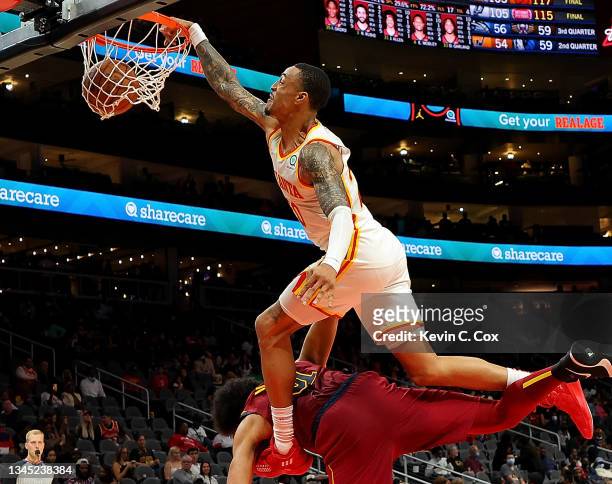 John Collins of the Atlanta Hawks dunks over Jarrett Allen of the Cleveland Cavaliers during the second half at State Farm Arena on October 06, 2021...