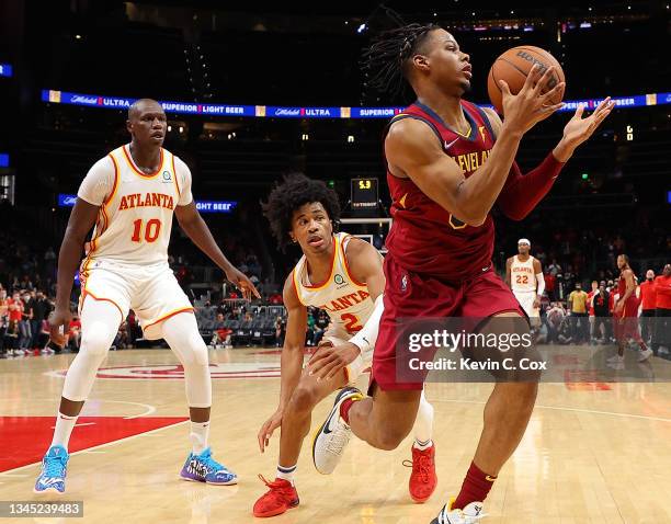 Isaac Okoro of the Cleveland Cavaliers grabs a rebound in the final seconds against Sharife Cooper and Gorgui Dieng of the Atlanta Hawks at State...