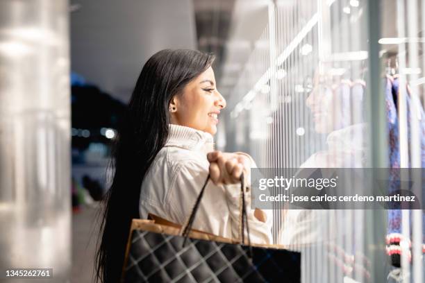 pretty south american woman with shopping bags black friday - black friday sale stock pictures, royalty-free photos & images