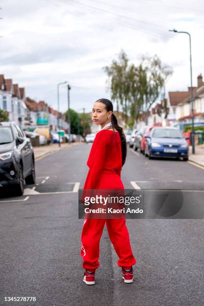uk, london, portrait of woman in red clothing on street - mirar por encima del hombro mujer fotografías e imágenes de stock