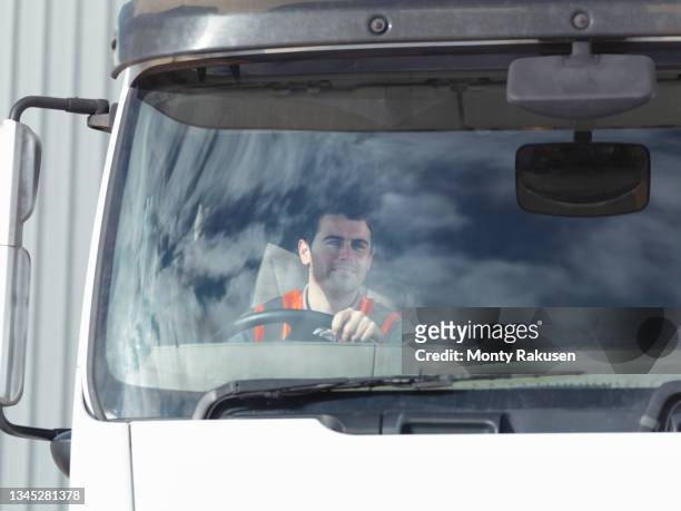 uk, smiling truck driver in truck cabin - lorry uk photos et images de collection